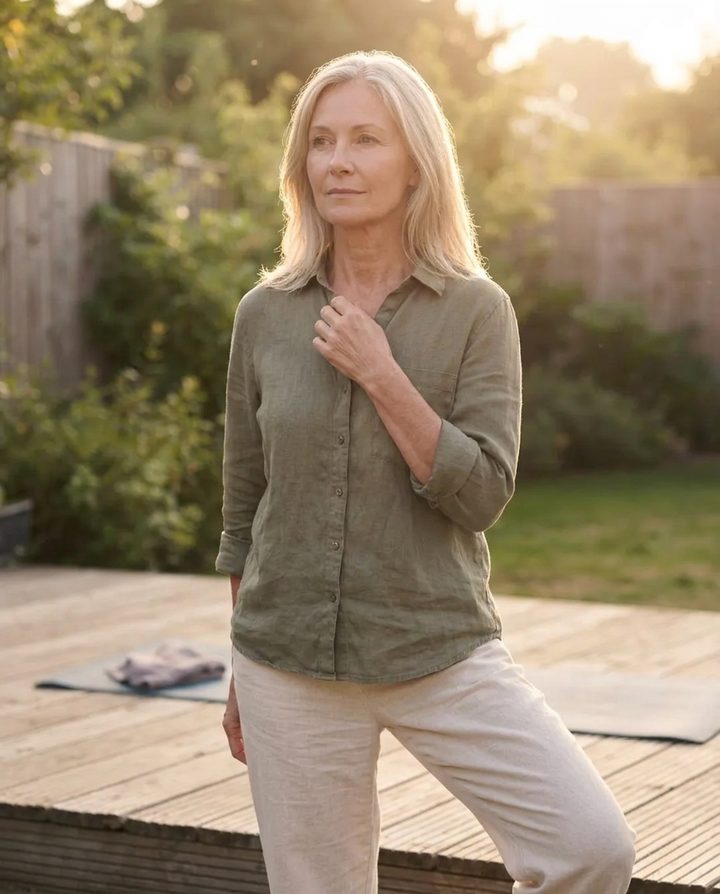 Woman in her 50s pausing to think about her health in a sunlit garden